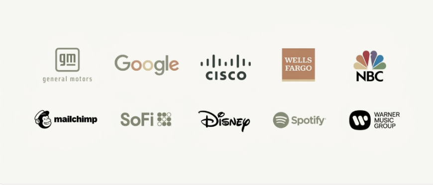 Logos of featured companies: General Motors, Google, Cisco, Wells Fargo, NBC, Mailchimp, SoFi, Disney, Spotify, and Warner Music Group